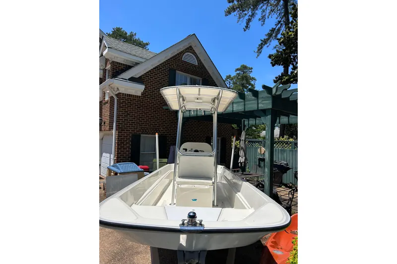 Slide: The Image of 1978 Boston Whaler 17 Montauk boat parked near a brick house. - 9