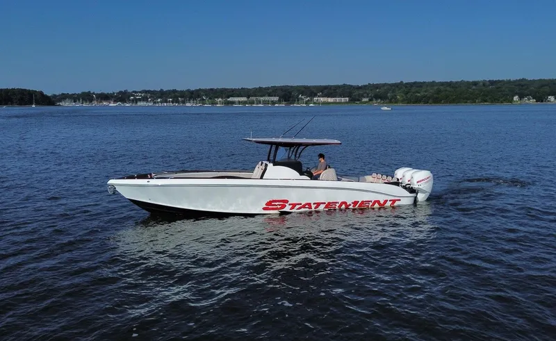 Slide: The Image of 2017 Statement 380 Open boat cruising on a calm lake under a clear blue sky. - 26
