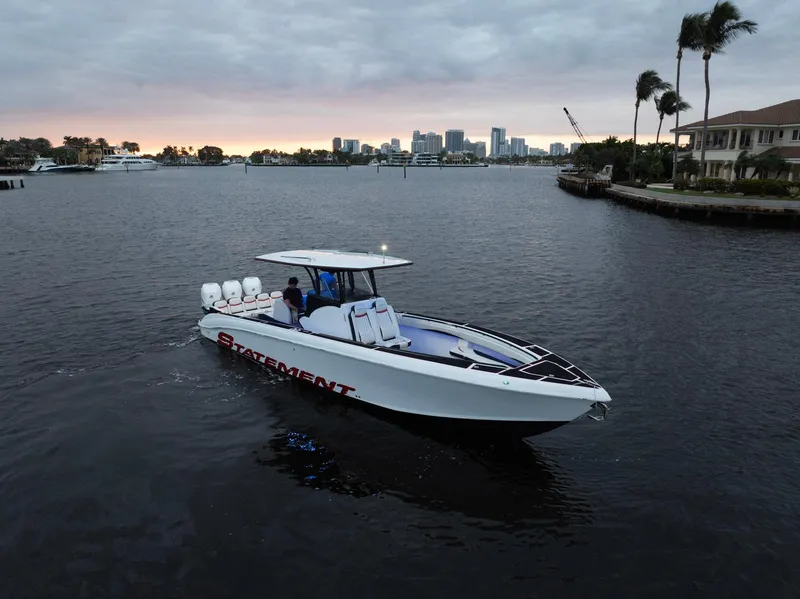 Slide: The Image of Statement 380 Open 2017 boat cruising on a calm waterway at sunset, city skyline in background. - 27