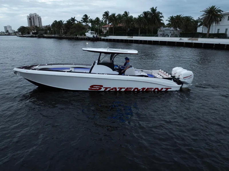 Slide: The Image of 2017 Statement 380 Open boat cruising on a calm waterway, surrounded by palm trees. - 36