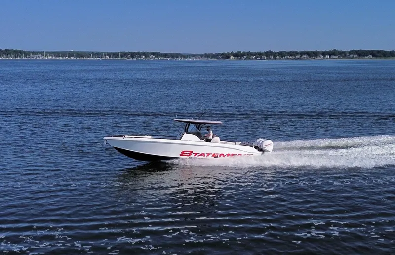 Slide: The Image of 2017 Statement 380 Open boat cruising on a calm lake under a clear blue sky. - 4