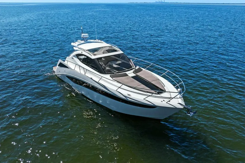 Slide: The Image of 2017 Galeon 385 HTS yacht cruising on open water under clear blue sky. - 2