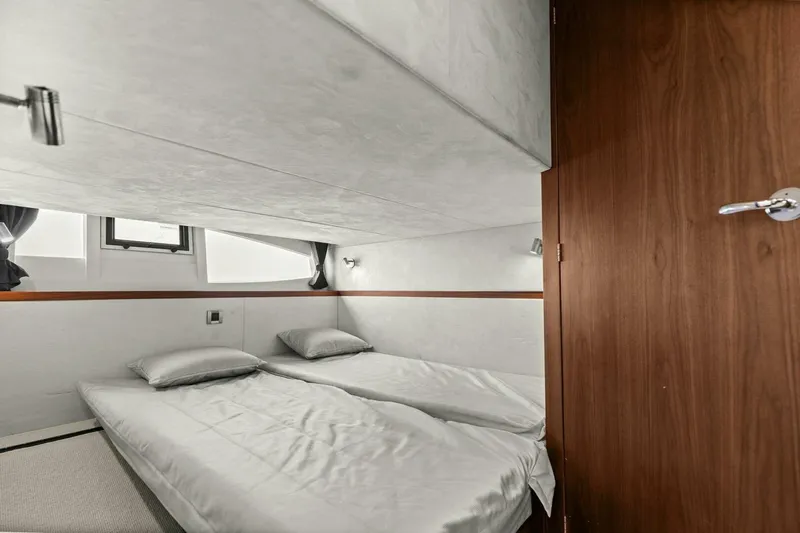 Slide: The Image of 2017 Galeon 385 HTS yacht cabin with twin beds, modern design, and wooden accents. - 42