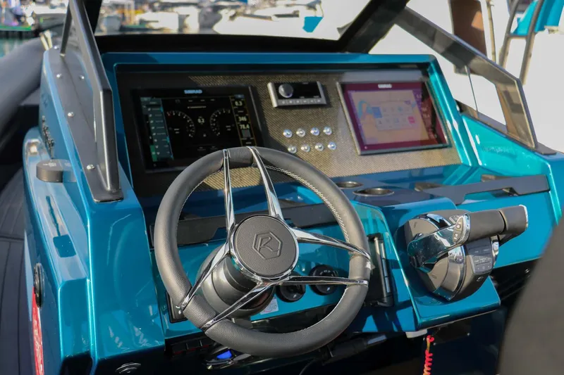 Slide: The Image of 2023 Roughneck 36 T Top boat dashboard with steering wheel and digital displays. - 11