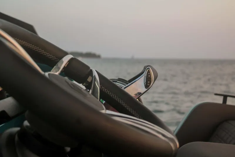 Slide: The Image of Close-up of Roughneck 36 T Top boat steering wheel, 2023 model, with ocean background. - 32