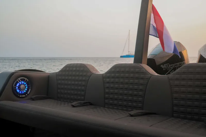 Slide: The Image of 2023 Roughneck 36 T Top boat interior with seating and speaker, ocean view in background. - 33