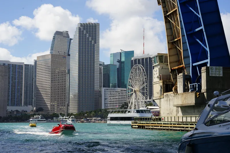 Slide: The Image of City skyline with boats, ferris wheel, and raised bridge over water. - 16