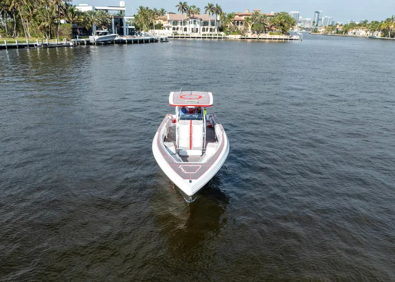 Slide: The Image of 2023 Fountain 38 SC boat cruising on a scenic waterway with luxury homes in the background. - 10