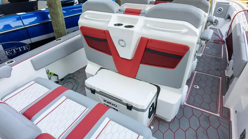 Slide: The Image of 2023 Fountain 38 SC boat interior with red and gray seating, Igloo cooler, and hexagonal flooring. - 32