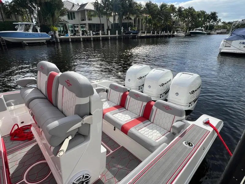 Slide: The Image of 2023 Fountain 38 SC boat with triple engines docked by waterfront homes. - 33