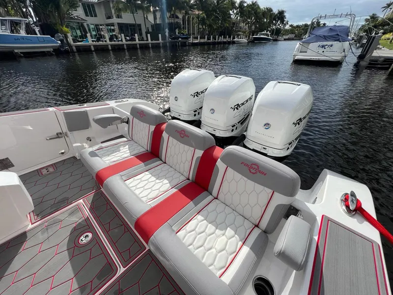 Slide: The Image of 2023 Fountain 38 SC boat with triple engines and stylish seating on a calm waterway. - 34