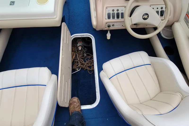 Slide: The Image of 1994 Sea Ray 180 Bow Rider interior with blue carpet and beige seats. - 18