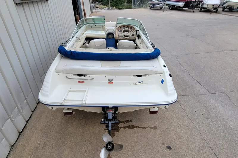 Slide: The Image of 1994 Sea Ray 180 Bow Rider boat, rear view, parked on concrete surface. - 2