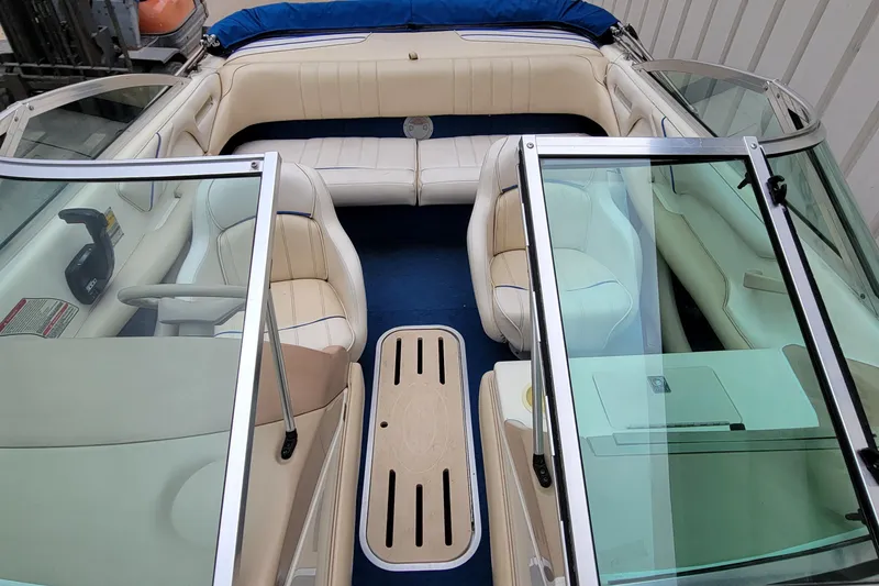 Slide: The Image of 1994 Sea Ray 180 Bow Rider interior with beige seating and blue carpet. - 26