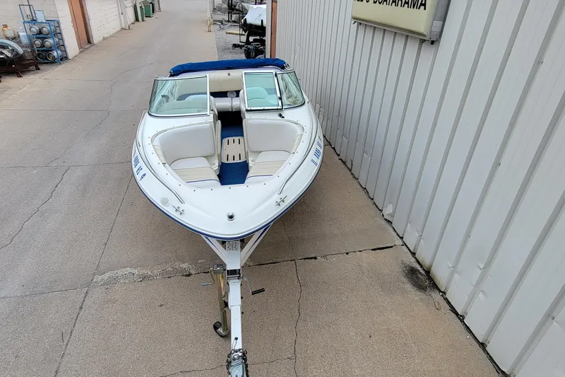 Slide: The Image of 1994 Sea Ray 180 Bow Rider boat on trailer, parked beside a building. - 8