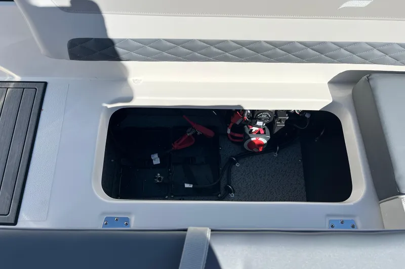 Slide: The Image of 2026 Starcraft SVX 211 OB boat storage compartment with visible battery and wiring. - 11