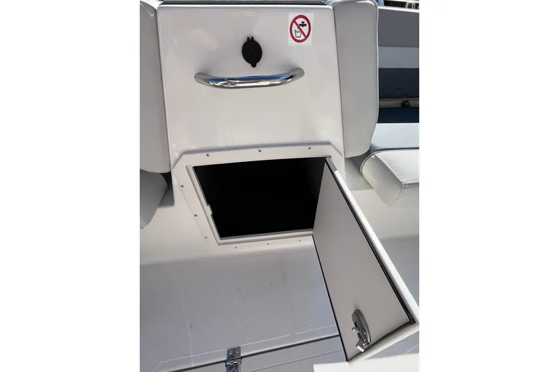 Slide: The Image of 2026 Starcraft SVX 211 OB boat storage compartment with open hatch and no smoking sign. - 14
