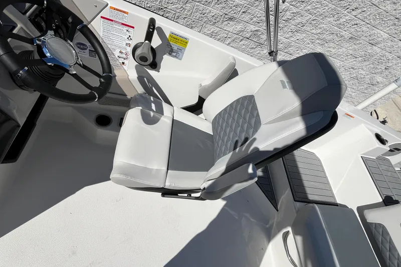 Slide: The Image of 2026 Starcraft SVX 211 OB boat interior with steering wheel and cushioned seating. - 22