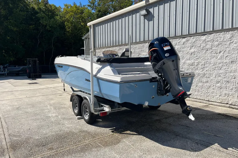 Slide: The Image of 2026 Starcraft SVX 211 OB boat on trailer, parked outdoors near a building. - 5