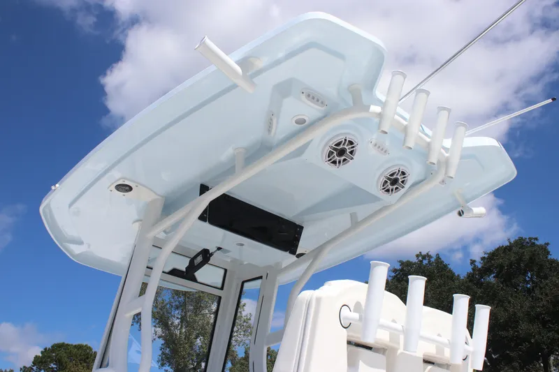 Slide: The Image of 2026 Tidewater 2700 Carolina Bay boat T-top with rod holders and speakers against blue sky. - 5