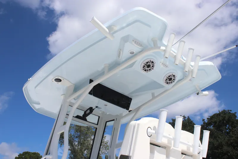 Slide: The Image of Tidewater 2700 Carolina Bay 2026 boat T-top with rod holders and speakers against blue sky. - 6