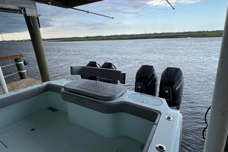 Slide: The Image of 2025 Front Runner 37 Catamaran docked, featuring triple outboard engines on a serene waterway. - 10