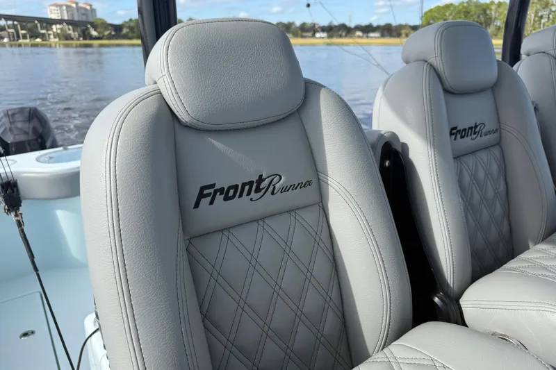 Slide: The Image of 2025 Front Runner 37 Catamaran seats with logo, featuring elegant stitching and waterfront backdrop. - 28