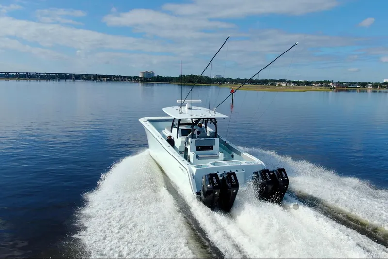 Slide: The Image of 2025 Front Runner 37 Catamaran cruising on a calm lake with fishing rods. - 43