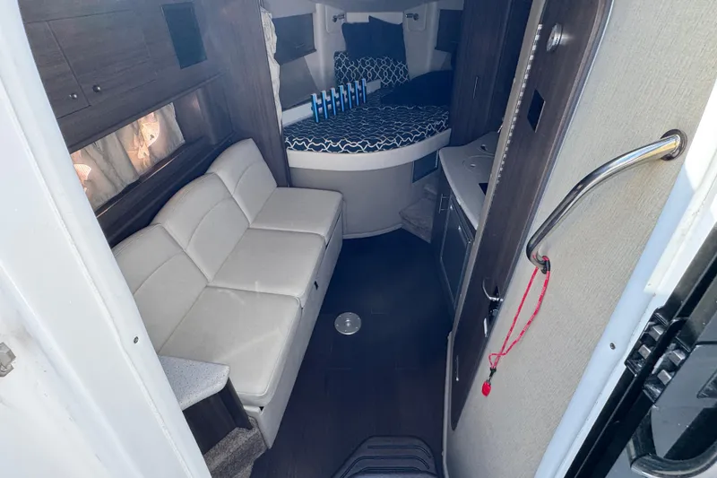 Slide: The Image of Interior of 2020 Rinker 320 EX boat with sofa, bed, and kitchenette. - 17