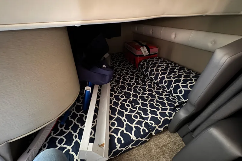 Slide: The Image of Interior cabin of 2020 Rinker 320 EX boat with patterned bedding and storage items. - 25