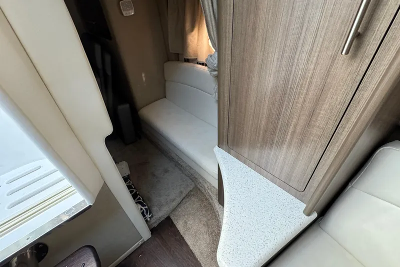 Slide: The Image of Interior of a 2020 Rinker 320 EX boat, featuring seating and wood cabinetry. - 26