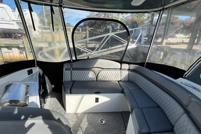 Slide: The Image of 2020 Rinker 320 EX boat interior with gray seating and clear canopy. - 4