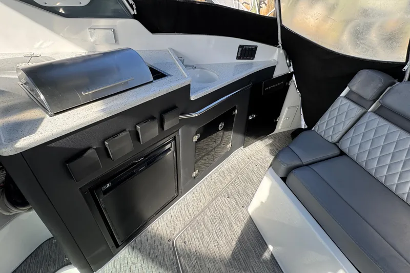 Slide: The Image of 2020 Rinker 320 EX boat interior with kitchenette and seating area. - 5