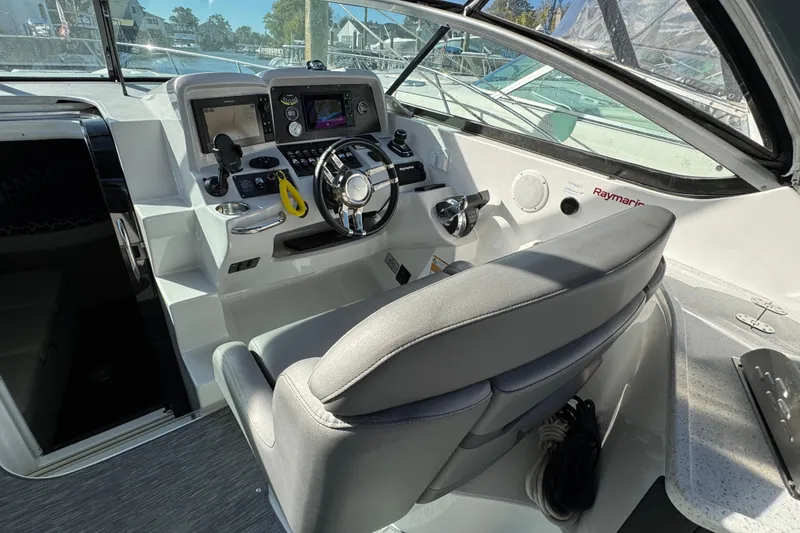 Slide: The Image of 2020 Rinker 320 EX boat cockpit with modern steering and navigation controls. - 8