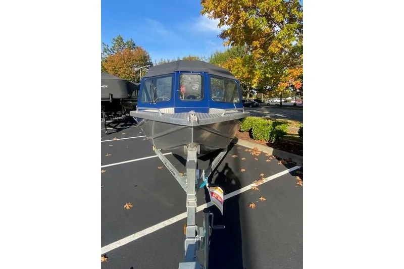 Slide: The Image of 2016 Thunderjet 186ECO boat on trailer in parking lot, surrounded by autumn trees. - 3