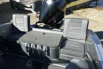 Slide: The Image of 2026 Ranger 2080MS boat interior with seating and motor, dockside view. - 79