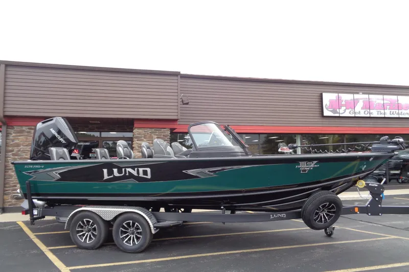 The Image of 2026 Lund 2175 Pro-V boat on trailer outside a marine store. - 0