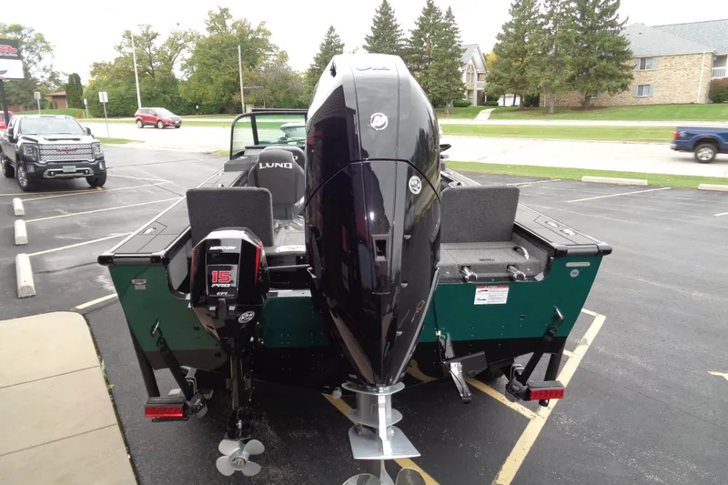 Slide: The Image of 2026 Lund 2175 Pro-V boat with dual Mercury outboard motors in a parking lot. - 11