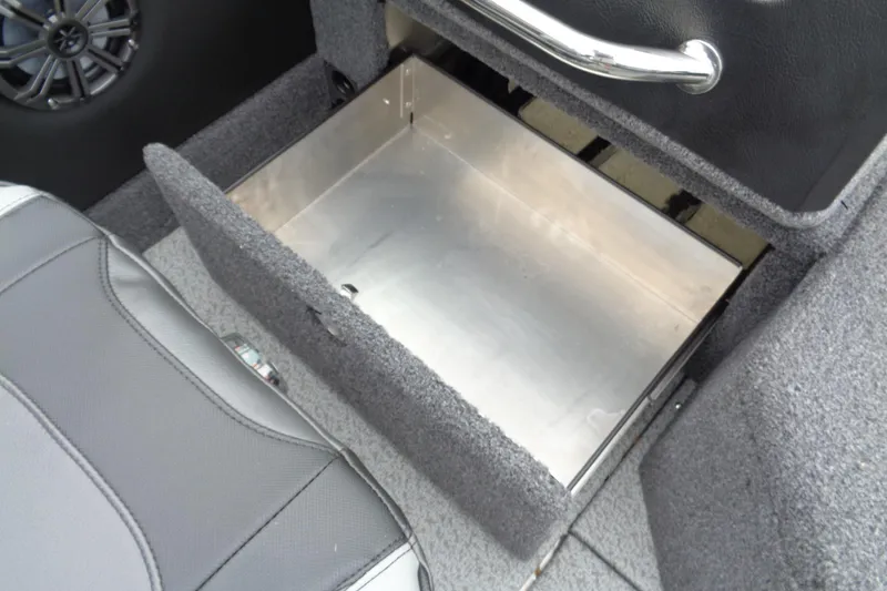 Slide: The Image of 2026 Lund 2175 Pro-V boat interior storage compartment with metallic finish and speaker detail. - 16