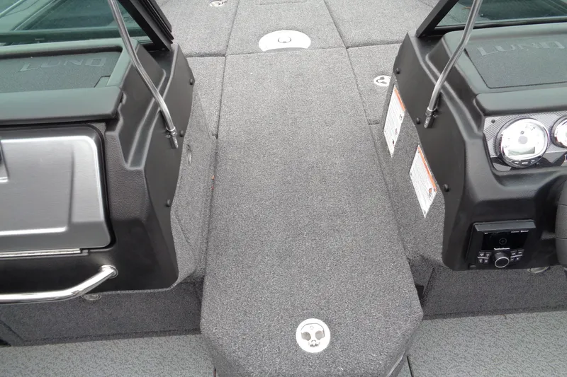 Slide: The Image of 2026 Lund 2175 Pro-V boat interior with gray carpet and dashboard controls. - 18