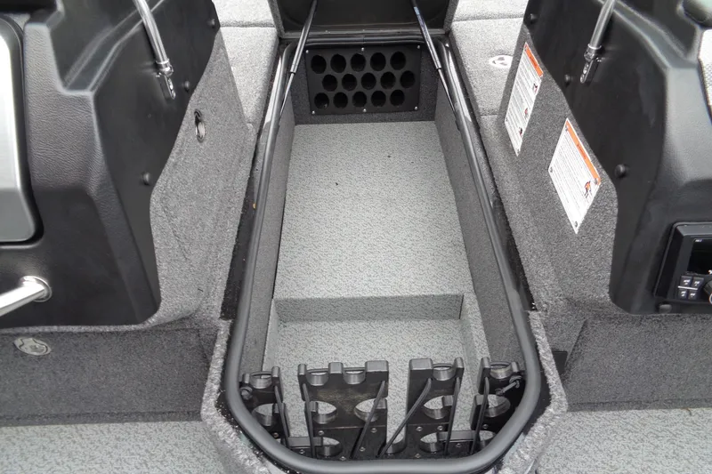 Slide: The Image of 2026 Lund 2175 Pro-V boat interior with rod storage compartment and carpeted flooring. - 19