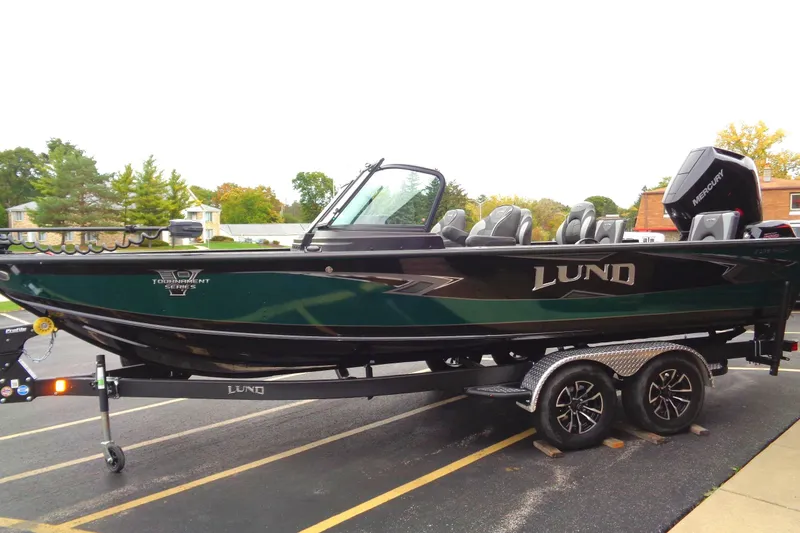 Slide: The Image of 2026 Lund 2175 Pro-V boat on trailer, parked outdoors, featuring sleek design and modern features. - 4