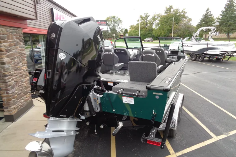 Slide: The Image of 2026 Lund 2175 Pro-V boat with powerful outboard motor, parked outdoors. - 6