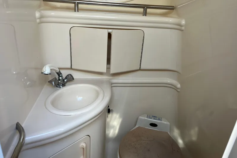 Slide: The Image of 2001 Sea Ray 280 Sundancer bathroom with sink, faucet, and storage cabinet. - 4