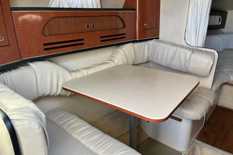 Slide: The Image of Interior of 2001 Sea Ray 280 Sundancer with cozy dining area and cushioned seating. - 6