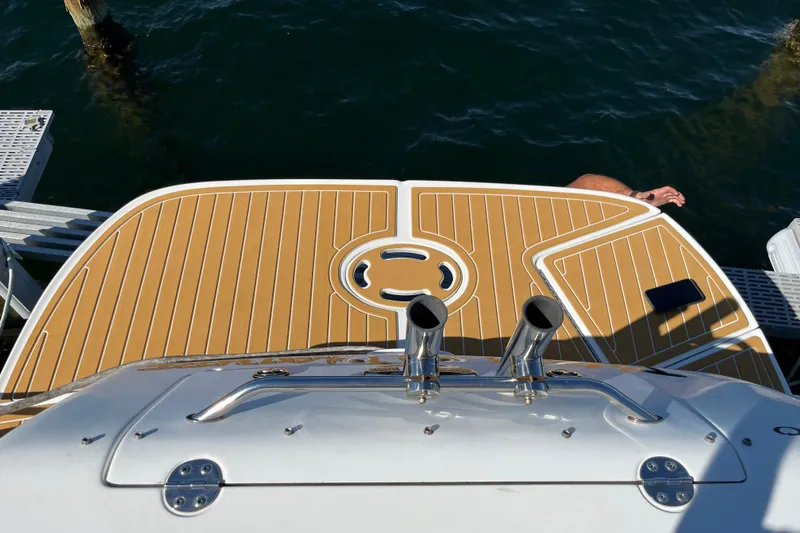 Slide: The Image of 2001 Sea Ray 280 Sundancer swim platform with teak decking, docked by the water. - 7