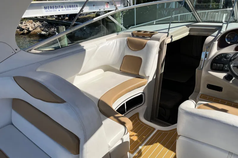 Slide: The Image of 2001 Sea Ray 280 Sundancer interior with beige and white seating, docked near Meredith Lumber. - 8