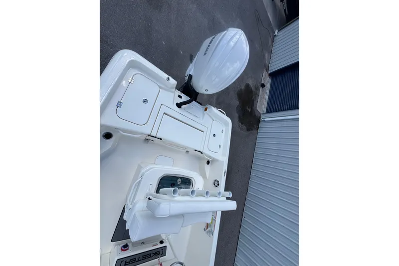 Slide: The Image of 2026 Skeeter SX2350 boat deck with Yamaha outboard motor, docked near a metal building. - 11