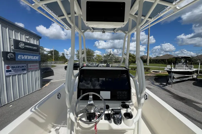 Slide: The Image of 2026 Skeeter SX2350 boat console with steering wheel, parked near marine dealership. - 16