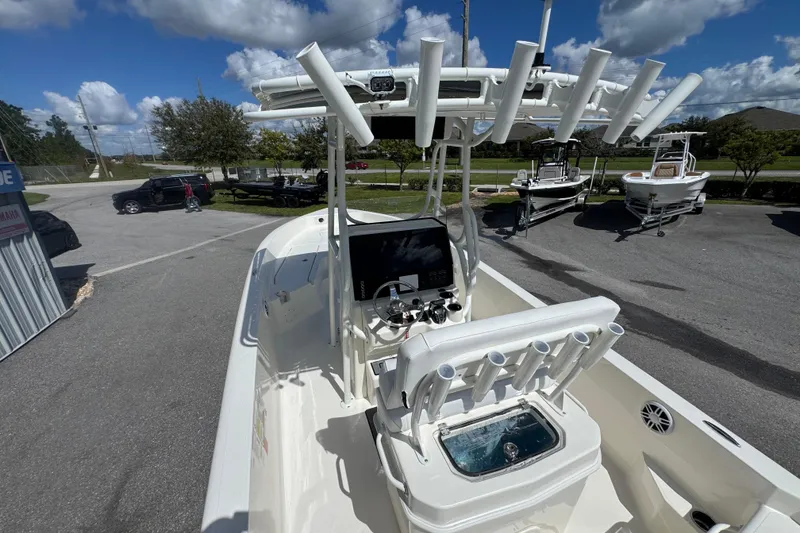 Slide: The Image of 2026 Skeeter SX2350 boat with advanced console and rod holders, parked outdoors under blue sky. - 17